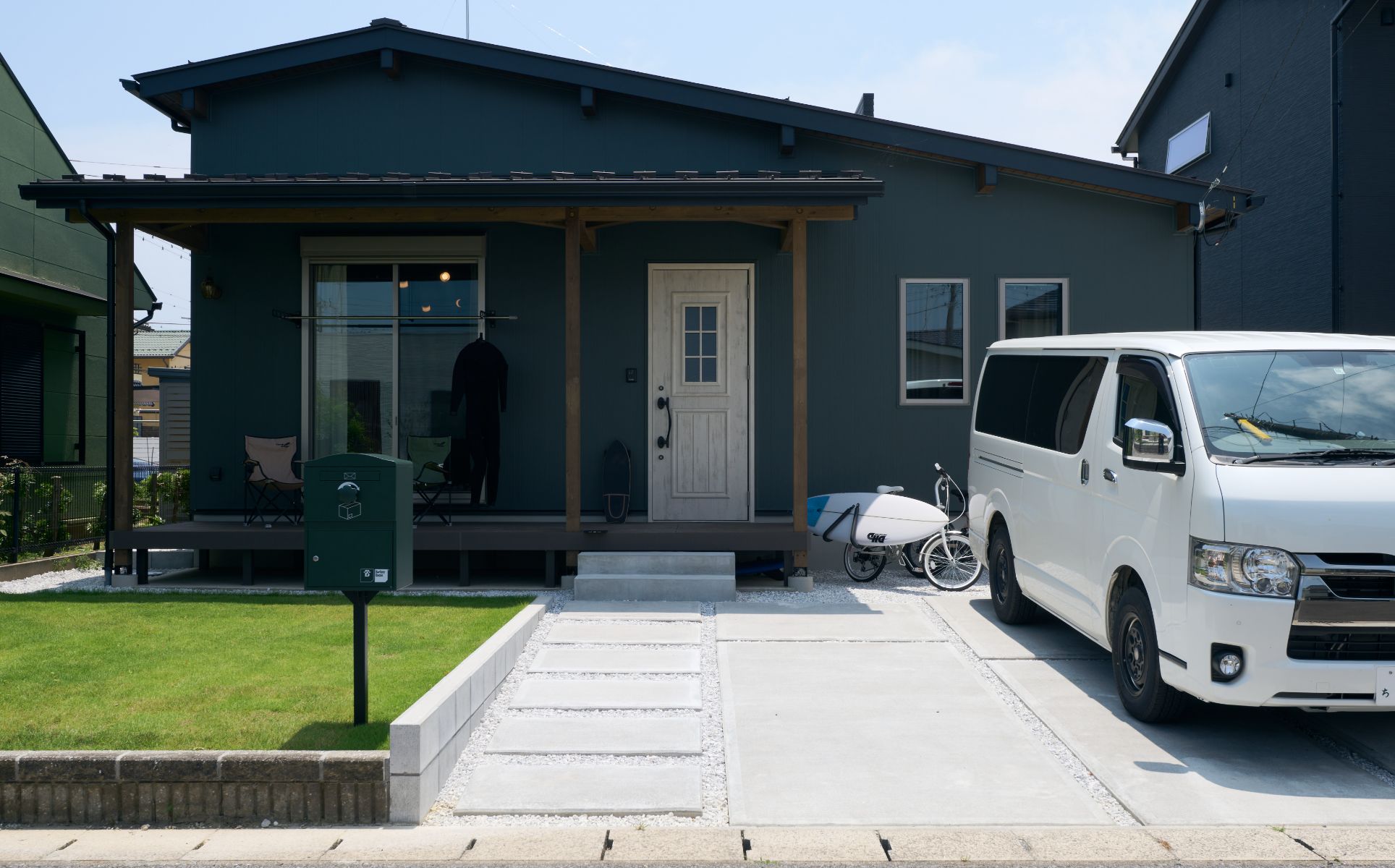 ホワイトの玄関ドアをアクセントにした、ウッドデッキのある外観